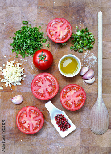 ingrédients pour préparation de tomates provençales sur planche de cuisine