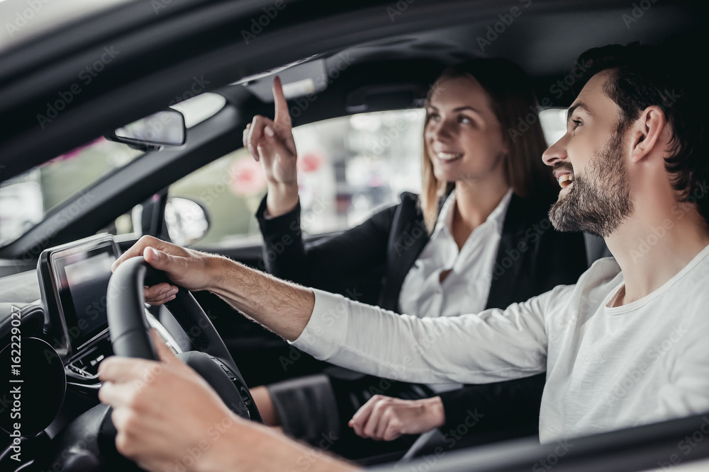 Salesperson with customer in car dealership Salesperson with customer in car dealership