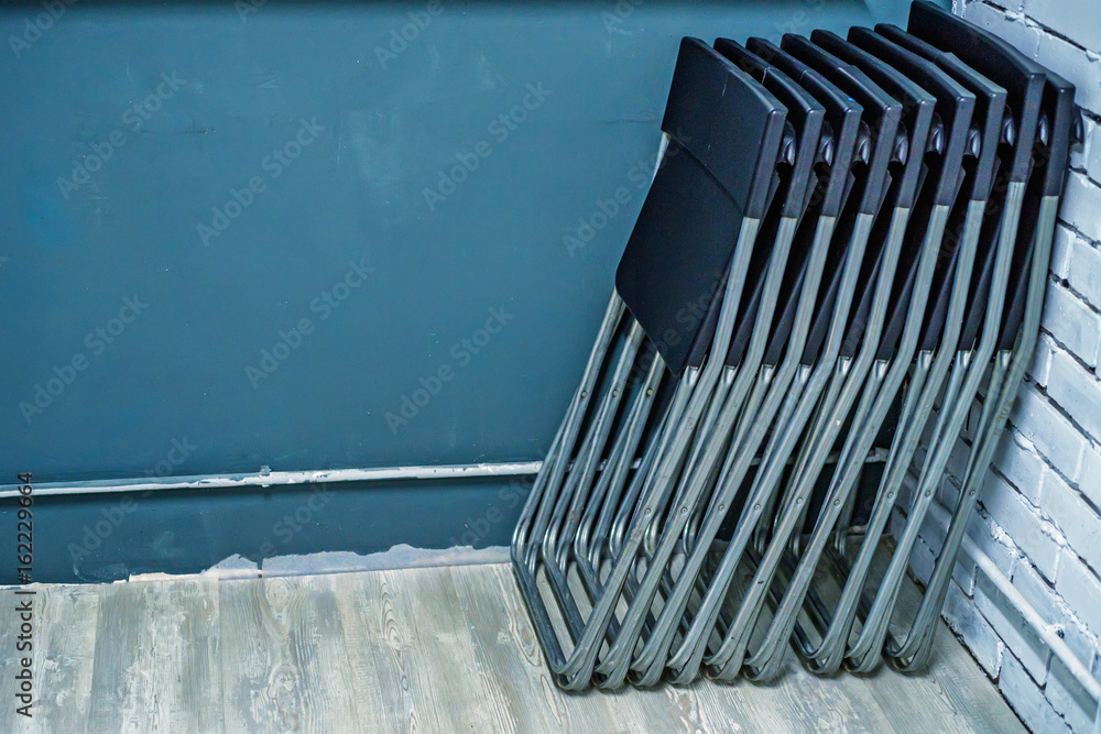 Fototapeta premium Set of black plastic folding chairs in office