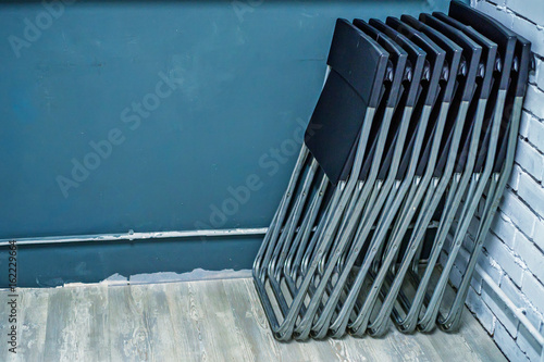 Set of black plastic folding chairs in office photo