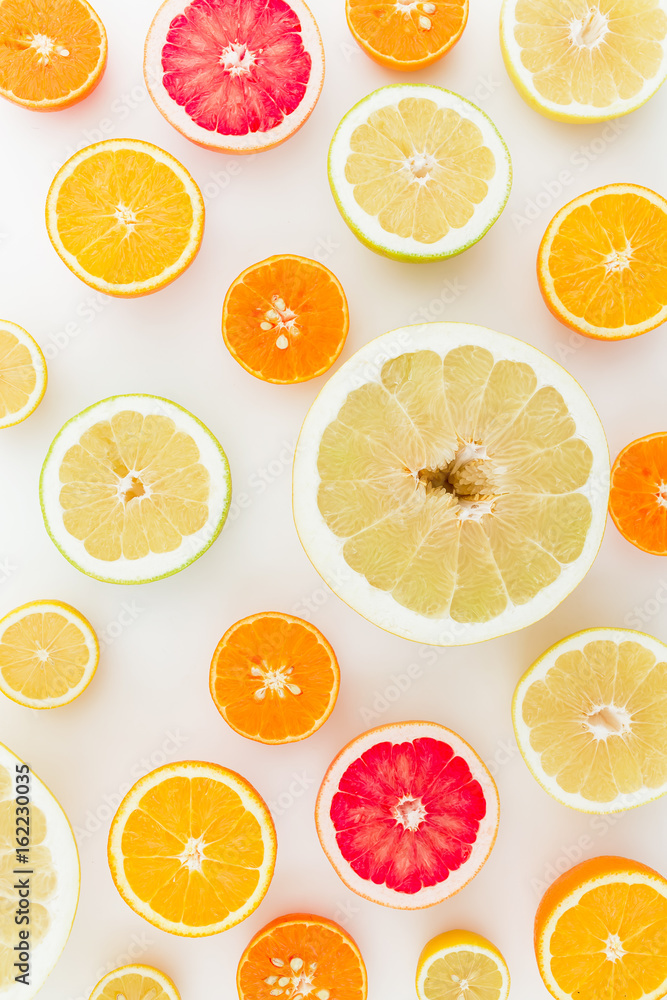 Sliced of tasty citrus fruits on white background. Flat lay, top view.