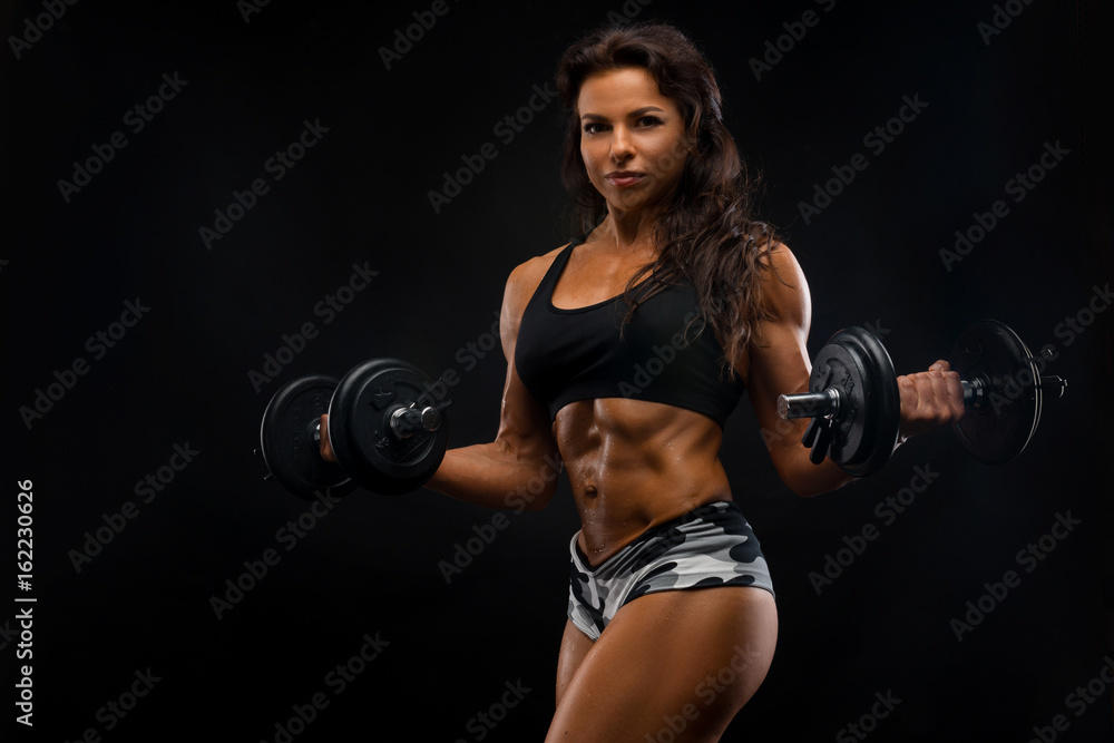 Perfect Fitness Body of Beautiful Woman. Fitness Instructor in Sports  Clothing. Female Model with Fit Muscular and Slim Body in Sportswear doing  Workout. Young Fit Girl Lifting Dumbbells. Stock Photo