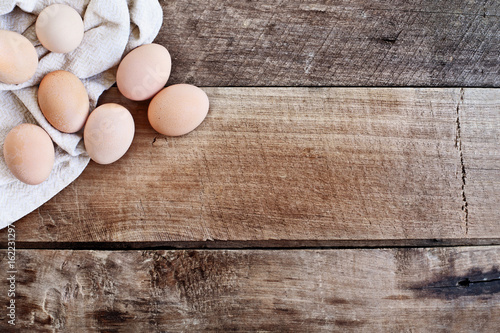 
Farm fresh organic brown chicken eggs from free range chickens over a rustic wooden background.