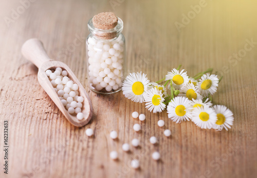 Herbal remedy alternative medicine. Chamomile flowers and homeopathic medication