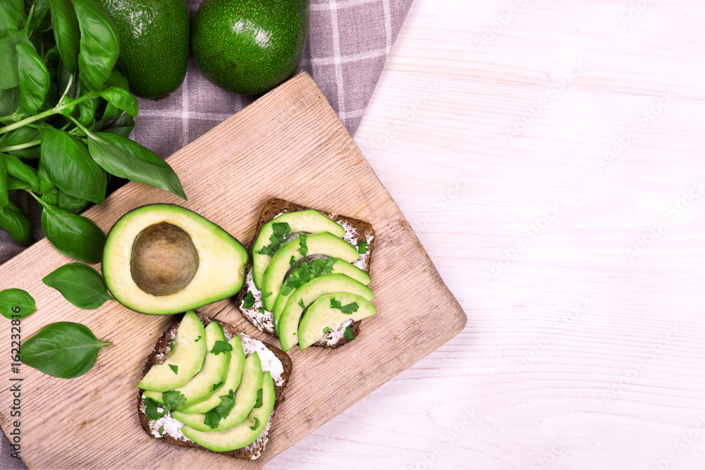 Avocado sandwich on dark rye bread made with fresh sliced avocados from above Avocado sandwich on dark rye bread made with fresh sliced avocados from above