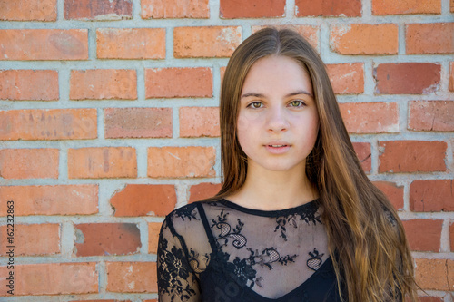 Beautiful teen girl over brick background © famiso