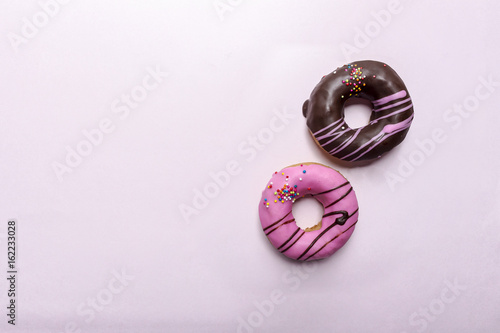 donut on pink paper texture with over light in the background