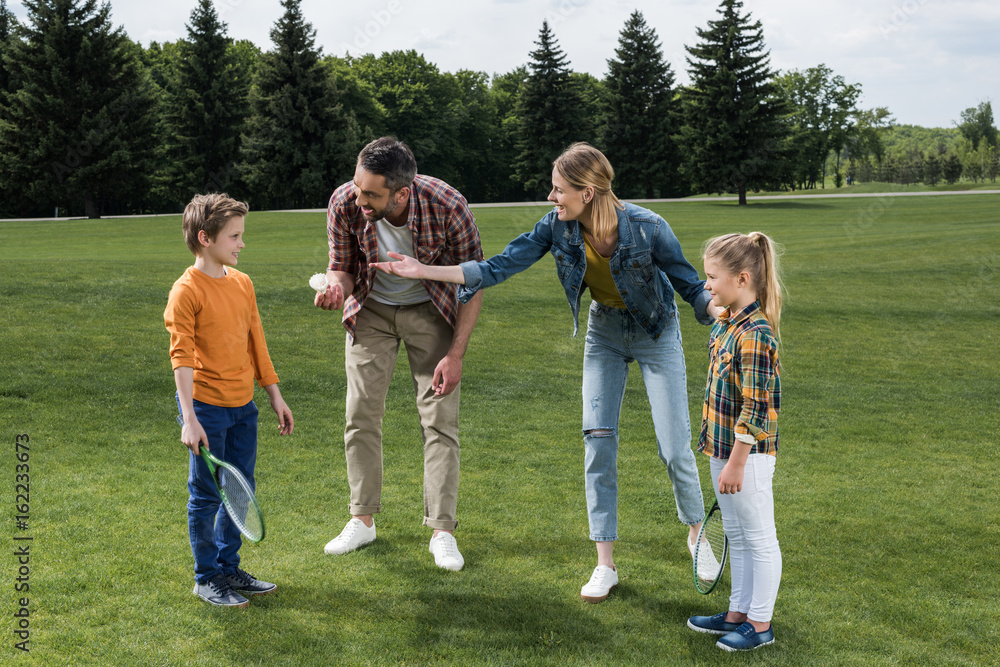 Obraz premium parents teaching little kids how to play badminton outdoors