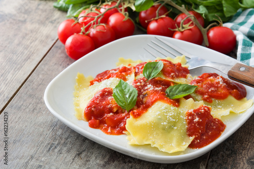 Ravioli with tomato sauce and basil on wooden table 