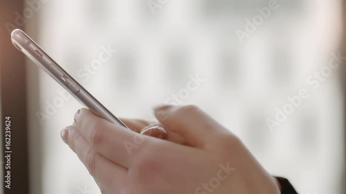Businesswoman Texting on Smartphone  Businesswoman writing a sms Message in an office. Shot on a Red Dragon in 4k down convert to HD.