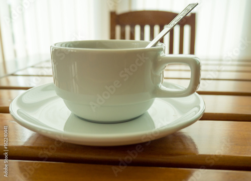 A cup of coffee on wooden table ,morning light background.