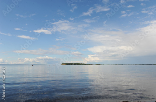 Water landscape on a summer clear day. Blue sky, clouds. Islands far away © sorocka