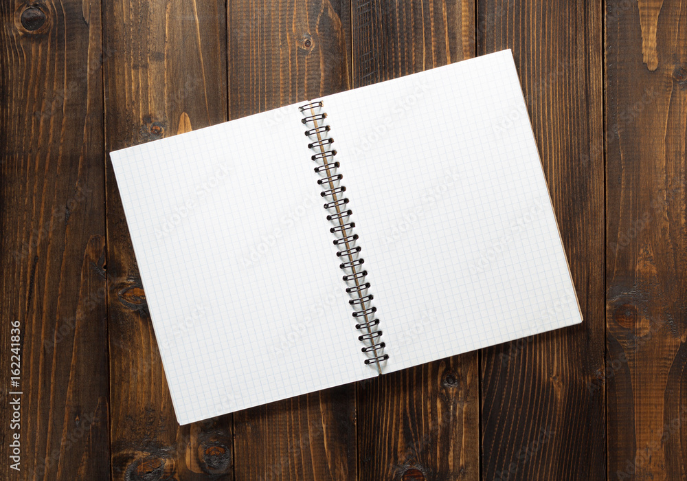 checked notebook on brown wood checked notebook on brown wood