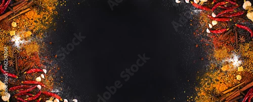 Obraz  z motywem Variety Spices and herbs on black stone background, Top view with empty space background for texture. Italian food, eastern food concept.