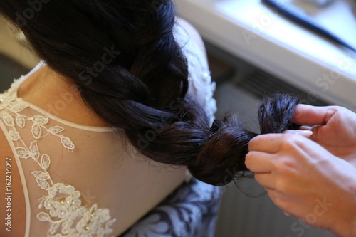 bride with dark hair is getting dressed