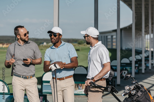 portrait of group of stylish golf players talking before game