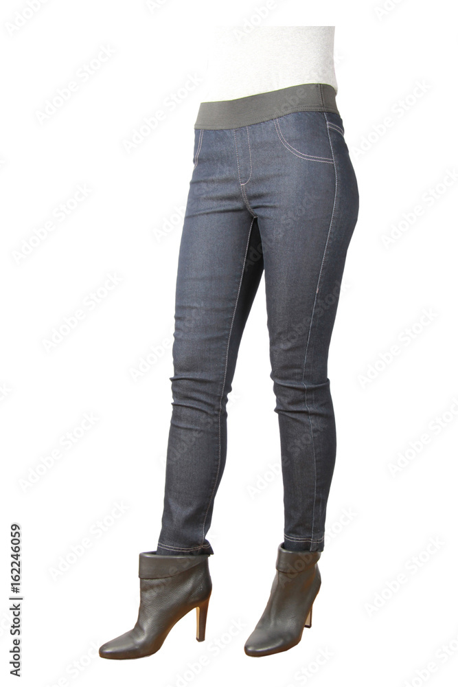 Slim woman in fashionable pants stands against a white background Slim woman in fashionable pants stands against a white background