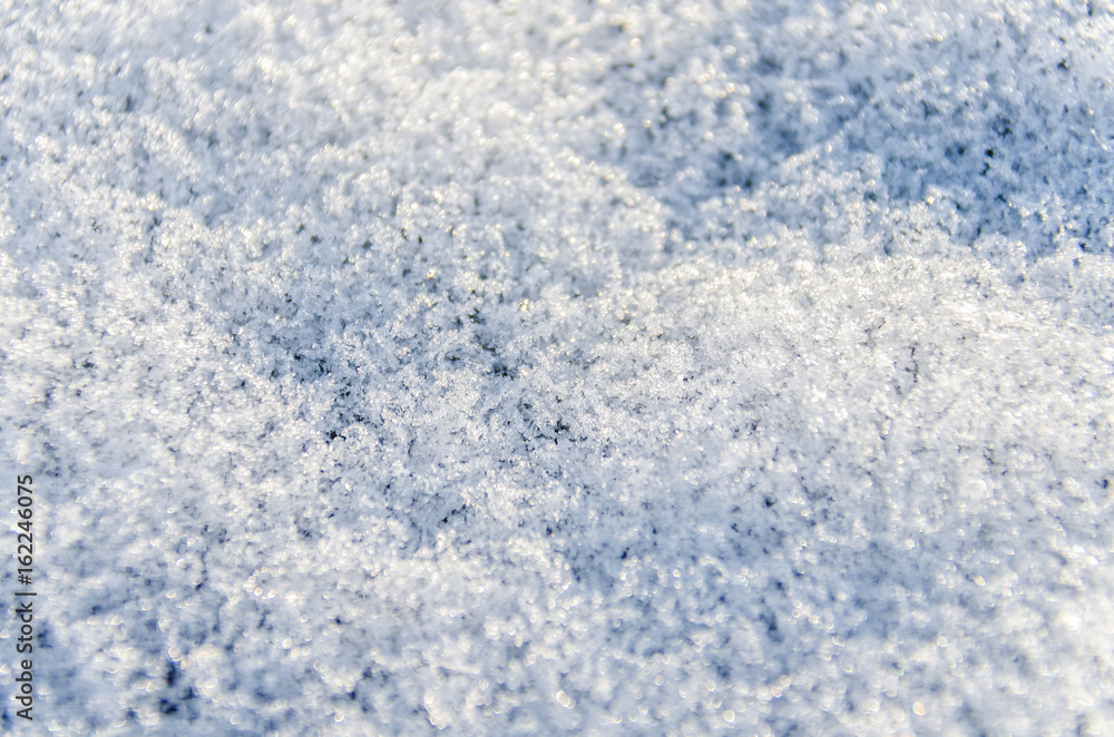 Macro closeup of heavy layer of snow ice crystals showing detail and texture on ground in winter