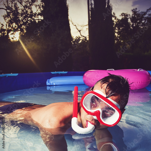 man swimming in a portable swimming pool photo