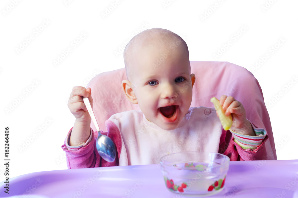 Smiling baby girl sitting on baby chair eats a lemon, isolated white background Smiling baby girl sitting on baby chair eats a lemon, isolated white background