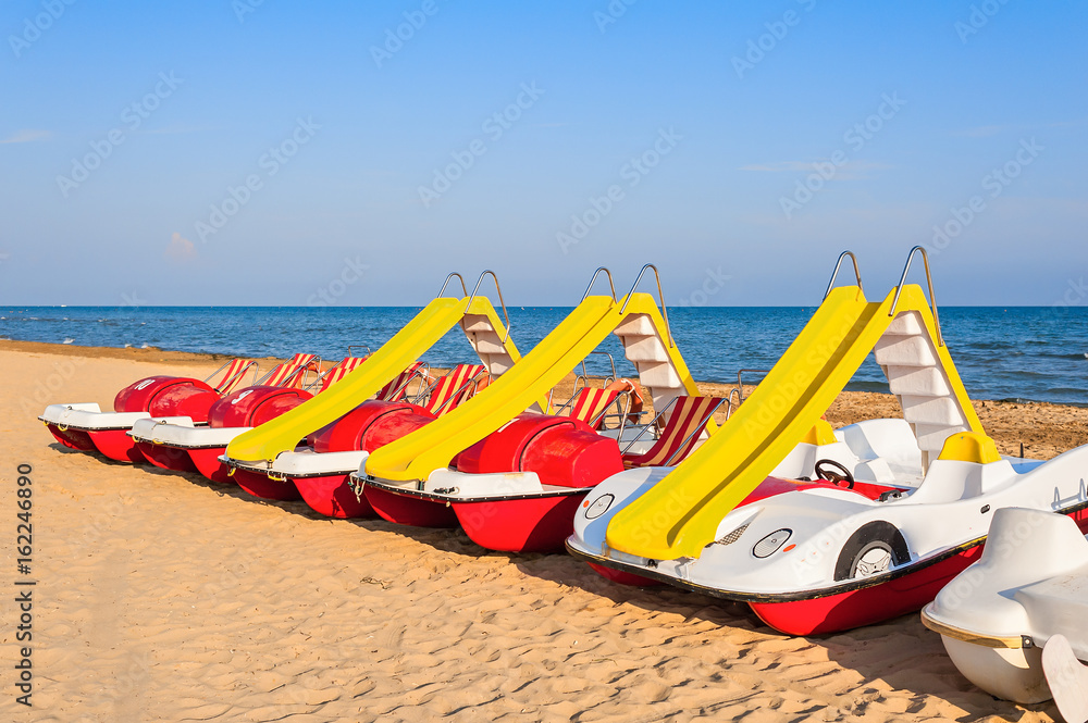 Pedal-boats with water slides on the beach. Pedal-boats with water slides on the beach.