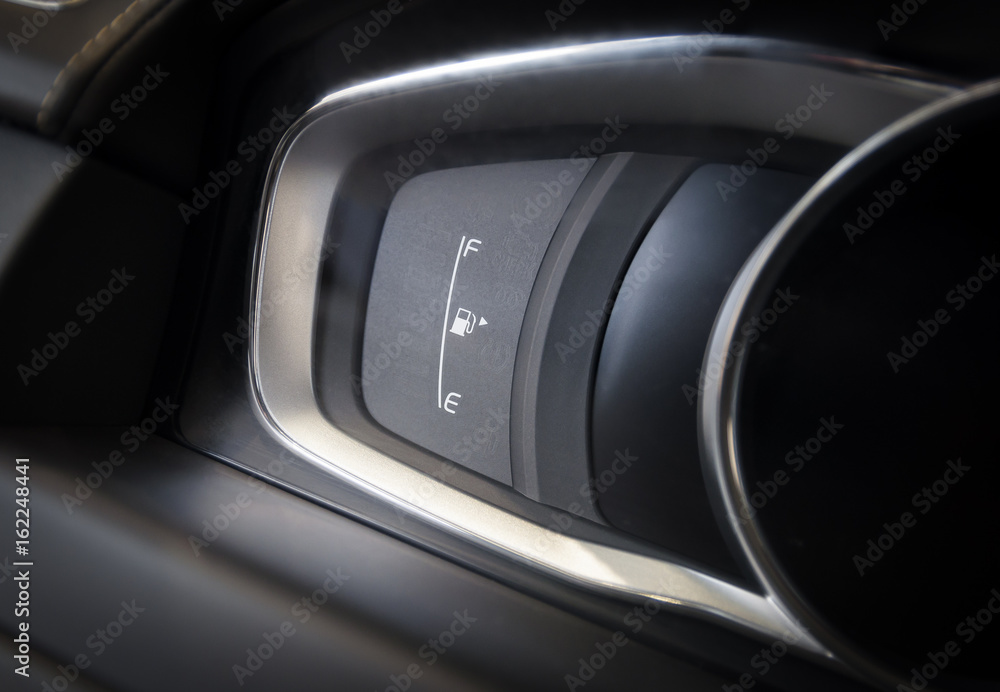 Fuel gauge close up, modern car dashboard interior