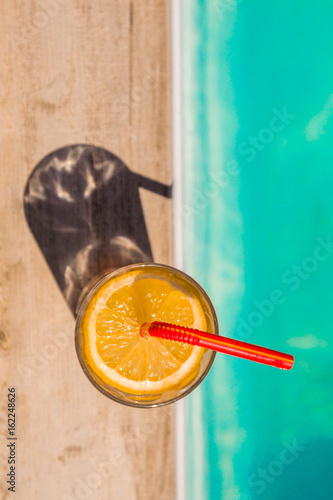 cocktail avec rondelle de citron au bord de la piscine