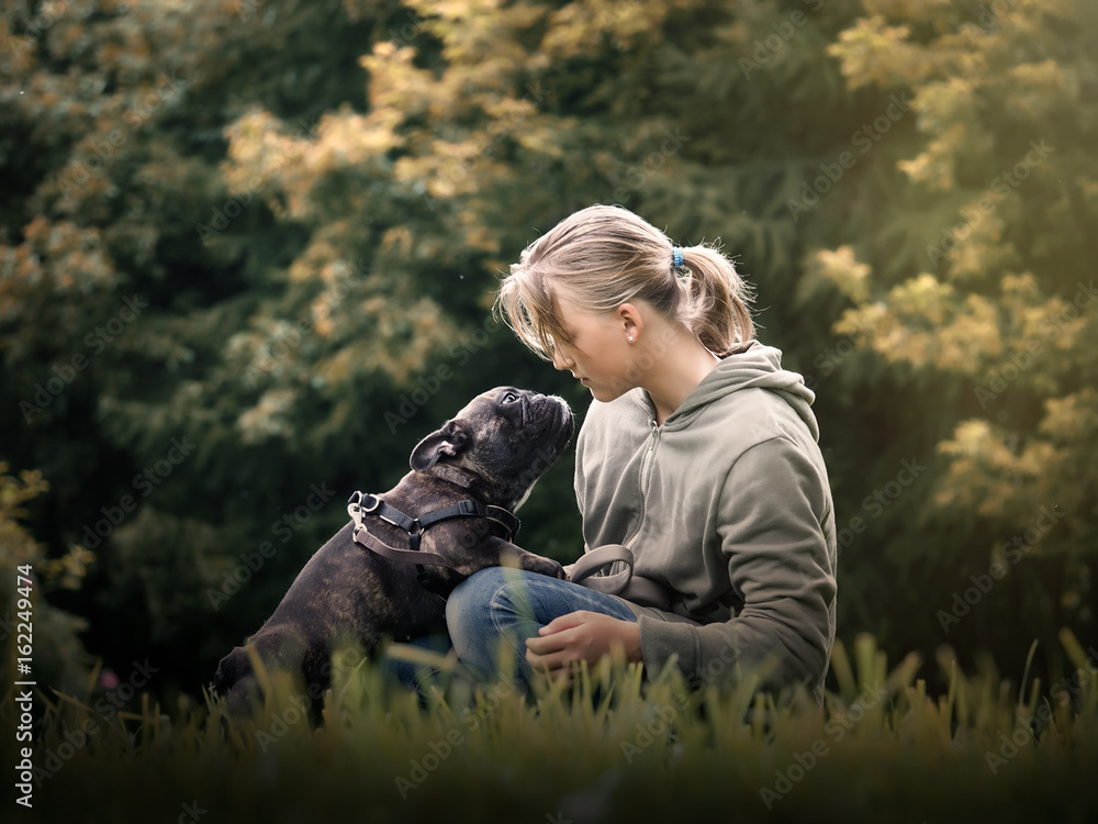 The girl talks to the dog. Nature, green grass, beautiful