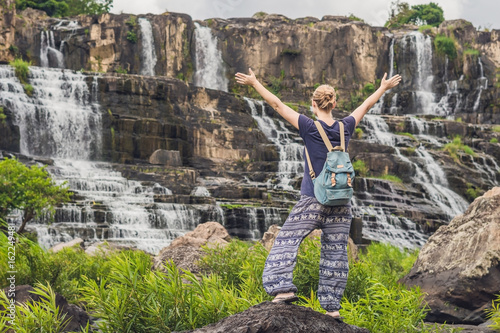 Young woman hiker, tourist on the background of Amazing Pongour Waterfall is famous and most beautiful of fall in Vietnam. Not far from Dalat city estimate 45 Km. Dalat, Vietnam photo