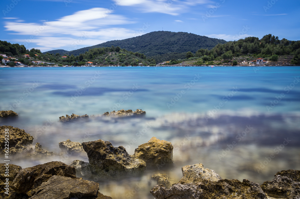 Blue water bay and rocks beach long exposure Croatia