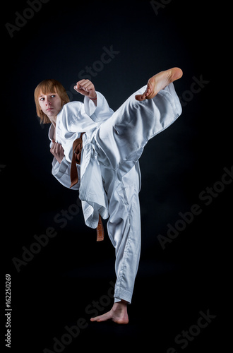 Young athlete in a kimono on a dark background