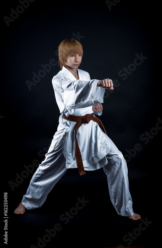 Young athlete in a kimono on a dark background