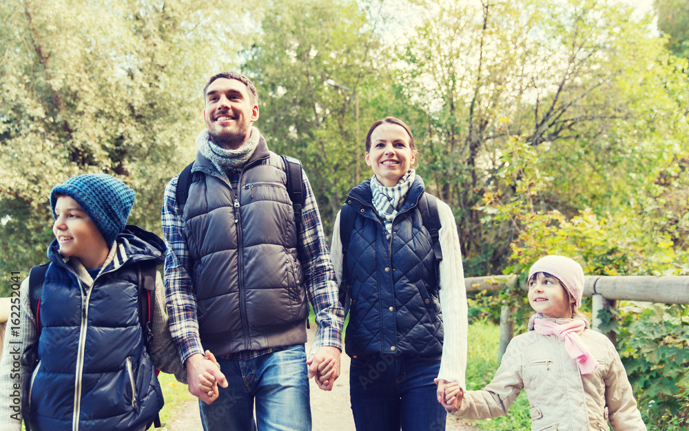happy family with backpacks hiking in woods happy family with backpacks hiking in woods