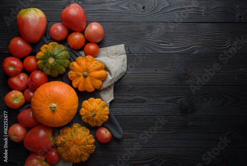 Composition of pumpkin squash and tomato on a wooden background