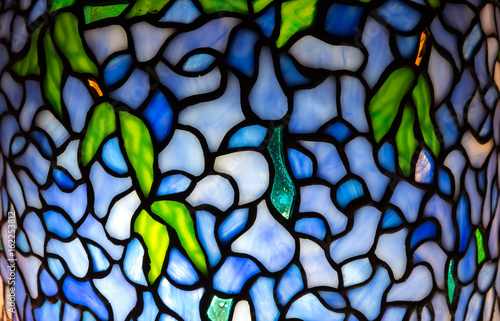 Fotografija Wisteria pattern illuminated stained glass close up detail.