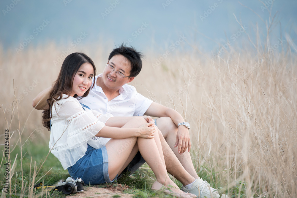 Beautiful young dating couple in city taking photos on park during sunset time Beautiful young dating couple in city taking photos on park during sunset time
