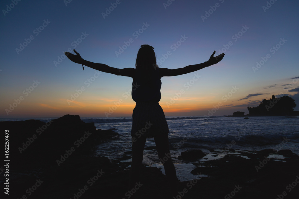 Girl enjoying the ocean with arms wide open.