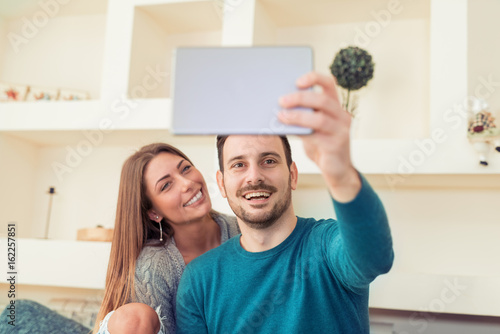 Cheerful couple taking a selfie with a smartphone photo