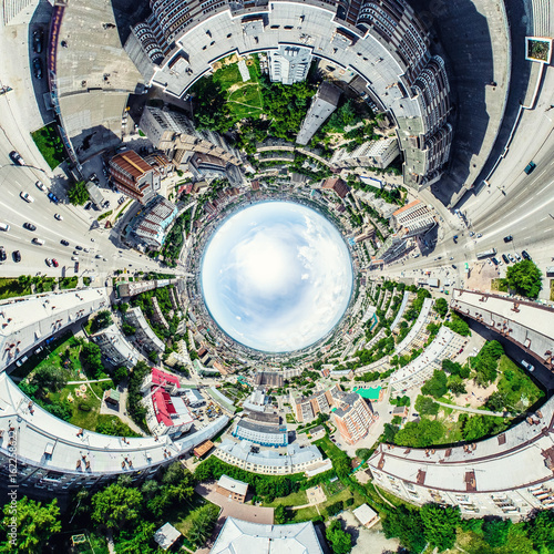 Aerial city view with crossroads and roads, houses, buildings, parks and parking lots, bridges. Helicopter drone shot. Wide Panoramic image.