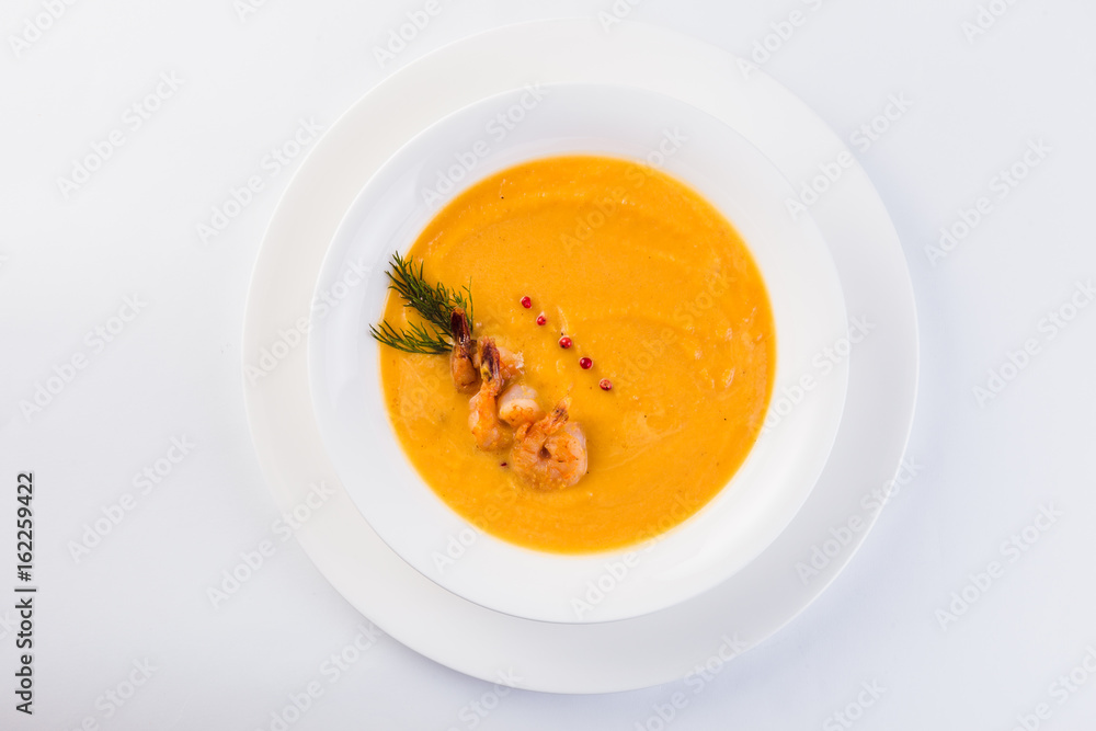 Fresh Creamy seafood soup with shrimps on a white plate on a light background (close top view) Fresh Creamy seafood soup with shrimps on a white plate on a light background (close top view)