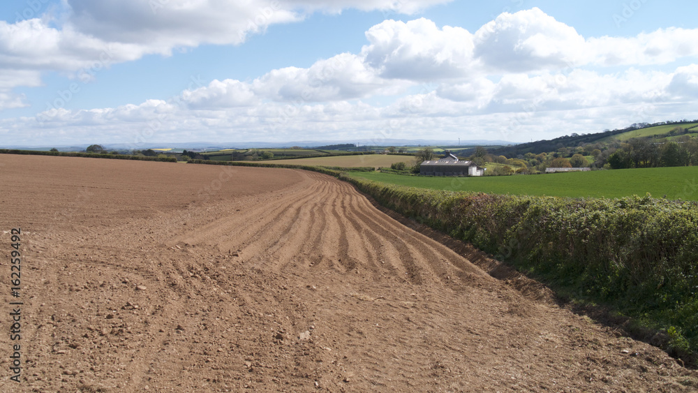 Ploughed field on a sunny & breezy day, countryside, UK.