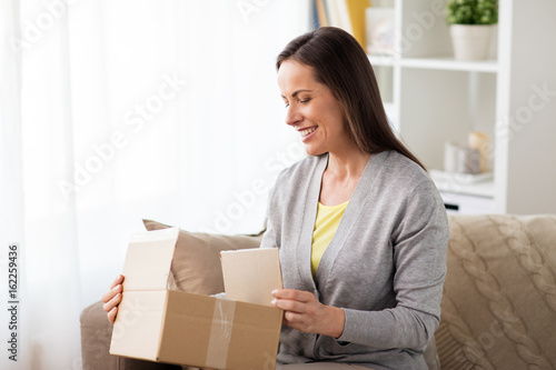 smiling woman opening cardboard box © Syda Productions