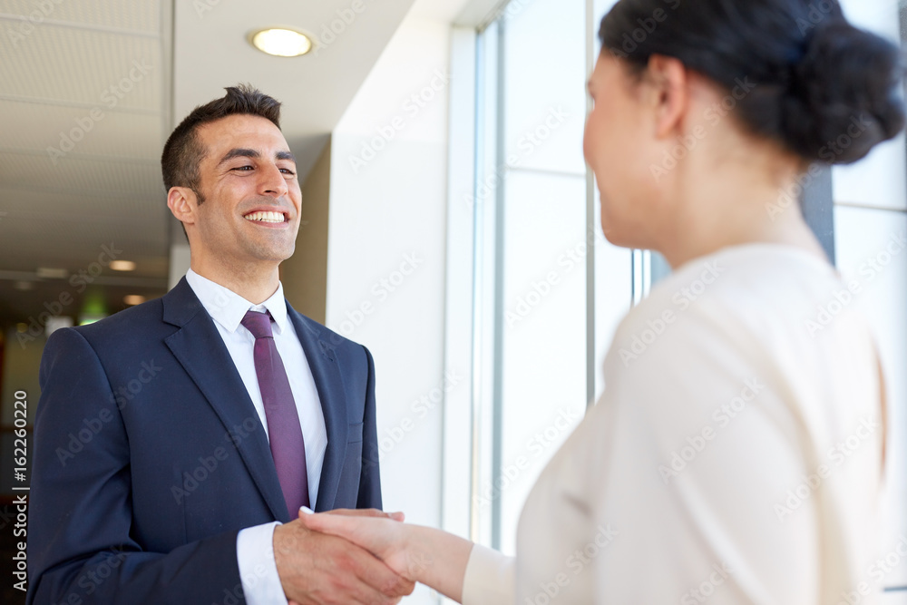 smiling business people shaking hands at office smiling business people shaking hands at office