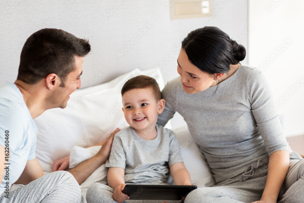 happy family with tablet pc in bed at home happy family with tablet pc in bed at home