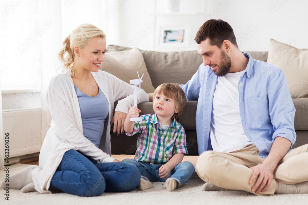 happy family playing with toy wind turbine