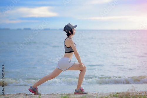 woman being exercise practice on the beach at sunset light