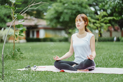 Woman relaxing Yoga in the park, Meditation for peace of mind.
