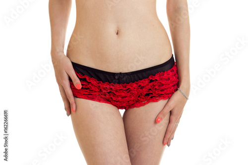 a close-up portrait of the body of a young girl facing the camera in red shorts with elastic stomach