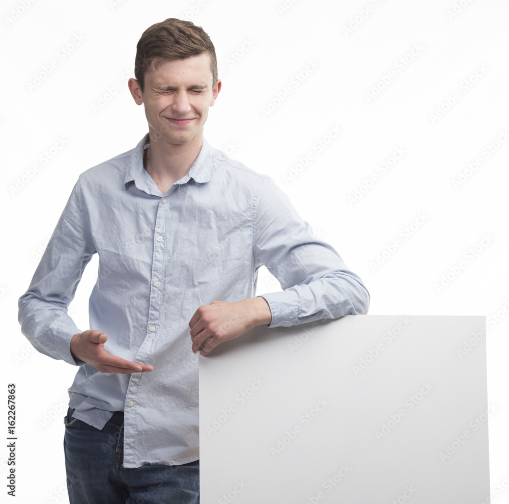 Young happy man portrait of a confident businessman showing presentation, pointing paper placard gray background. Ideal for banners, registration forms, presentation, landings, presenting concept. Young happy man portrait of a confident businessman showing presentation, pointing paper placard gray background. Ideal for banners, registration forms, presentation, landings, presenting concept.