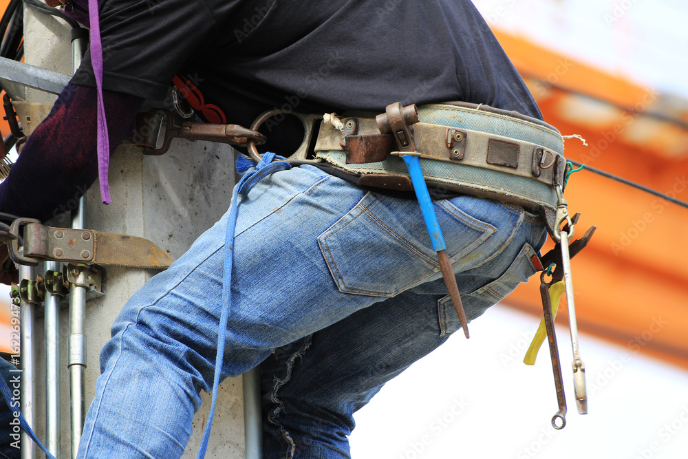 Tool Belt wearing by Electrician Climbing on Concrete Pole